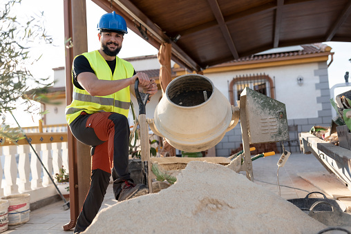 40-year-old construction worker renovating a house using concrete mixer