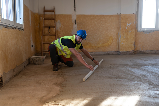 40-year-old construction worker renovating a house leveling floor
