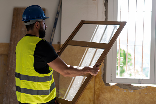 Construction worker changes home windows