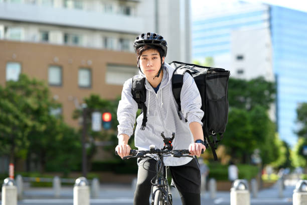 istock Young Asian man with backpack and providing delivery service on bicycle 1909509884