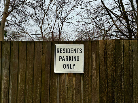 No parking sign on a wooden fence in a residential area