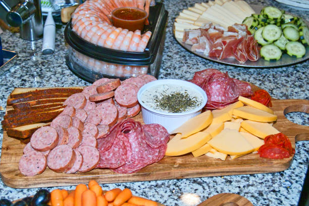 A wide display of meats, cheeses, and cucumbers - fotografia de stock