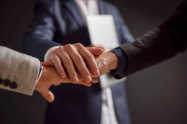 istock business people putting their hands together. Stack of hands. Unity and teamwork concept 1909551993