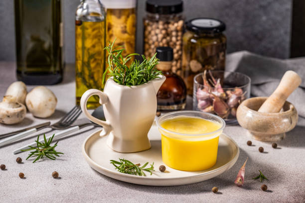 istock Melted butter in jar surrounded by ingredients for cooking and herbs 1909554923
