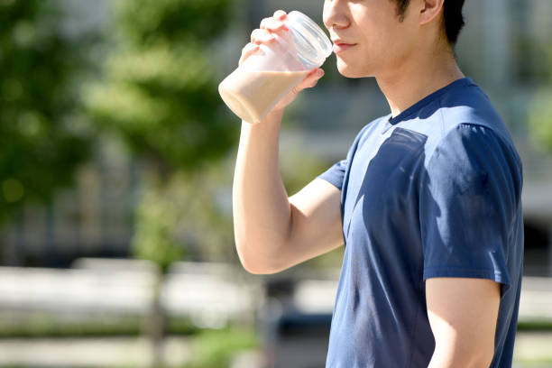 istock Young asian man drinking protein drink outdoors 1909566916