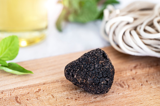 Black edible truffle, on wooden cutting board