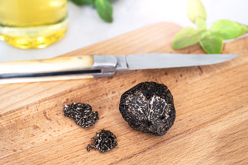 Black edible truffle, with ingredients on a wooden cutting board