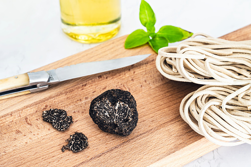 Black edible truffle, with ingredients on a wooden cutting board