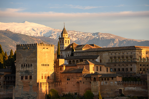 The Alhambra in Granada, Spain is one of the top tourist destination in the Andalusia region. Seen here at sunset from a distance with the Sierra Nevada mountains in the background. Photo taken March 25, 2017.