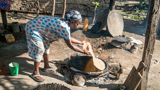 Ethiopia - 24 October 2023: Ethiopian woman expertly cooks injera, a common flatbread