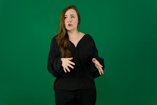 woman on a green background chromakey in a black striped mens shirt different emotions facial expression close-up advertising space for text clean. kind eyes