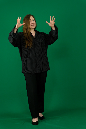 woman on a green background chromakey in a black striped mens shirt different emotions facial expression close-up advertising space for text clean. kind eyes