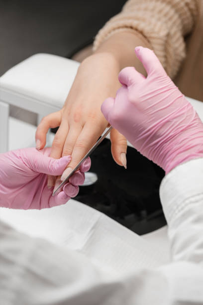 istock Preparing nails for manicure. Manicurist doing gel nails for a client. 1909678605