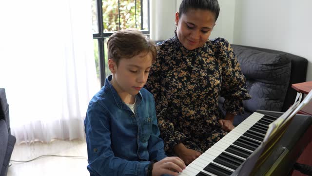 Teacher keyboardist gives synthesizer classes to a child at home