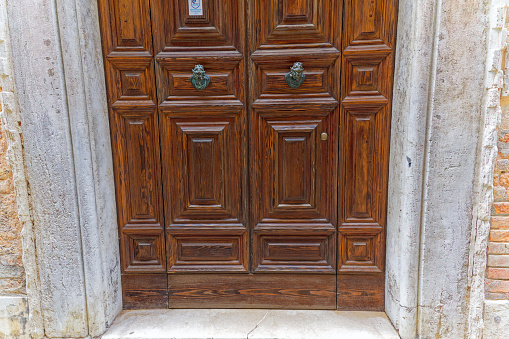 Close-up of entrance with wooden door of University Ca Foscari at City of Venice on a bright sunny summer day. Photo taken August 7th, 2023, Venice, Italy.