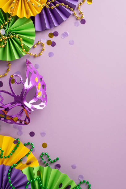 istock Cheerful Carnival Array: Top view vertical photograph capturing spirit of celebration with carnival mask, fans, beads garlands against lively violet background, perfect for text or advertisements 1909720868