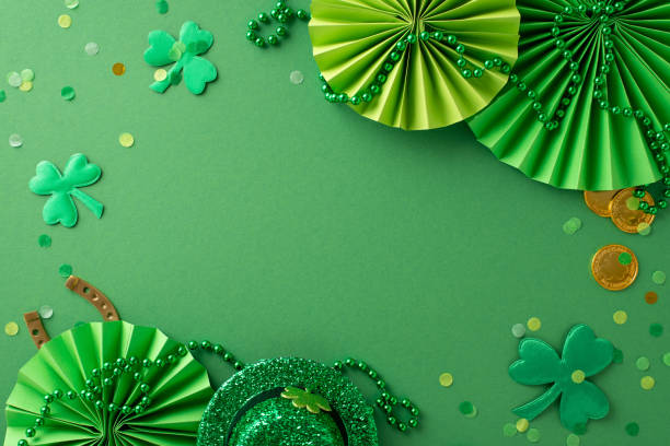 istock Iconic Saint Patrick's Day elements unite in this top view: leprechaun's hat, fortunate horseshoe, gold coins, fans, clovers, confetti, beaded garland arranged on green surface. Space for text or ad 1909720879