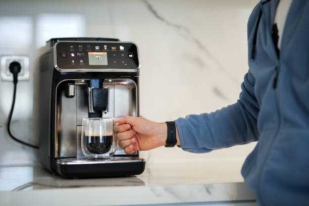 istock Preparing Morning Coffee in the Coffee Machine and Starting the Day, Touching Technology 1909736339