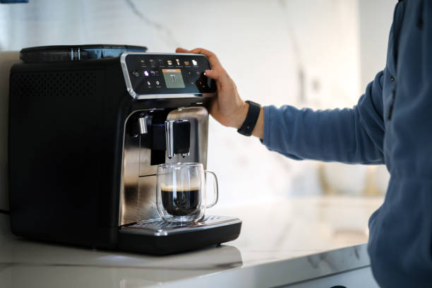 istock Preparing Morning Coffee in the Coffee Machine and Starting the Day, Touching Technology 1909737034