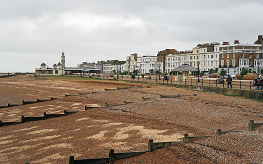 Herne Bay, Kent, United Kingdom, December 29, 2023. Holiday resort town seafront promenade, beach and buildings exterior. Overcast winter day outdoors.