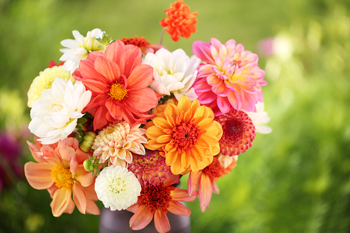 Beautiful bouquet of bright flowers in basket isolated on white background.