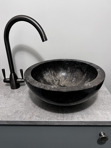 Black marble bowl and graphite tap in a modern bathroom