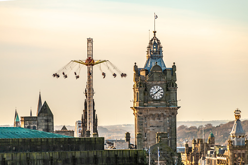 Edinburgh, UK. 26 December 2023. Chair swing ride and clock tower in Edinburgh