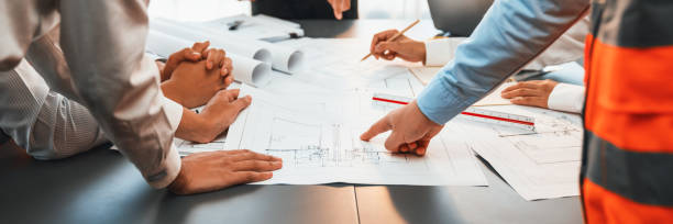 istock Engineer partner drawing and working on blueprint design together. Insight 1909830875