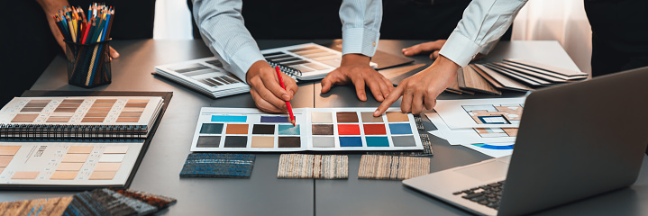 Group of professional interior designer and architect working together, planning and choosing color samples in office for house design or renovation. Insight