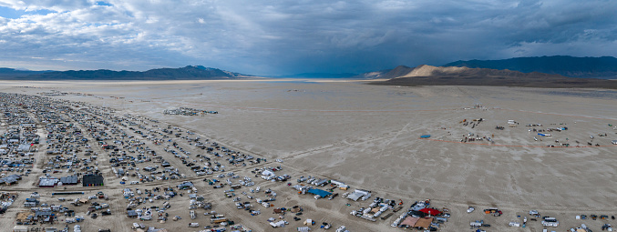 People camping in a desert during a heavy storm. Aerial shot of the camp city from above.