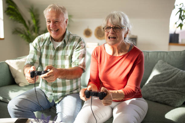 istock Modern old couple playing video game 1909848396