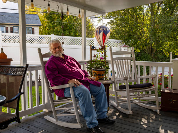 istock Elderly man resting on a rocking chair on a deck, enjoying his retirement 1909854730