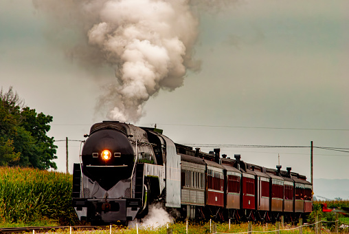 A vintage steam locomotive engine chugging along the railroad tracks