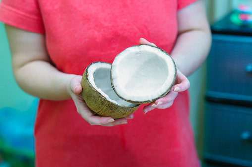 Hands holding a broken coconut