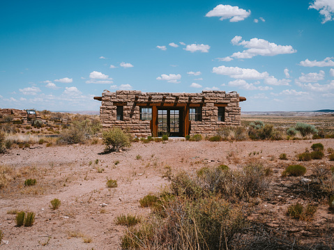 An antiquated stone house standing alone in the arid desert.