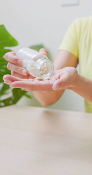 istock woman pour pills on hand 1909891162