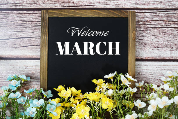 istock Welcome March text message with flower decoration on wooden background 1909925795
