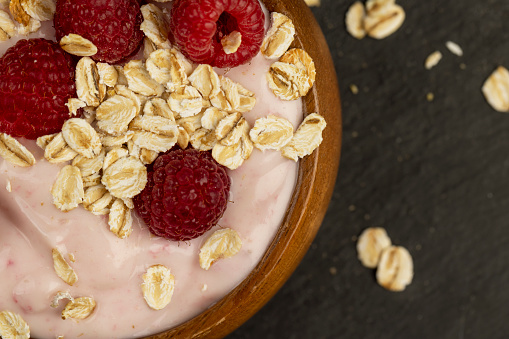 fresh yogurt with raspberry flavor and oat flakes , milk yogurt with raspberry flavor and aroma with red berries
