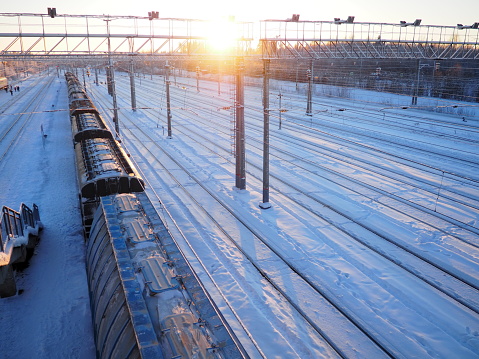 Svir, Russia,01.02.24: Svir railway station on the Oktyabrskaya railway. Passenger freight trains on rails. People and passengers walk along the platform. Winter short polar day. Snow and snowdrifts.