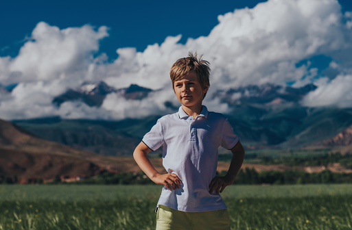 Portrait of boy on mountains background in summer