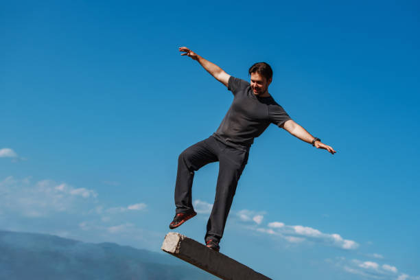 Young man balancing on mountains backgrounds stock photo