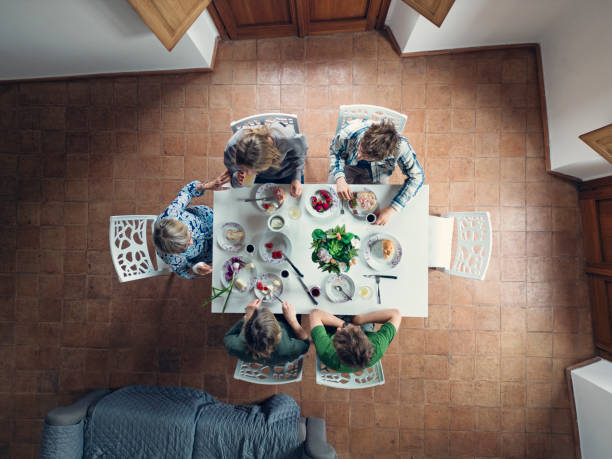 Table top view of mother, grandmother and three teenage kids having breakfast. Family is enjoying time together and fresh, delicious Italian food.Shot with DJI Mini 3 Pro