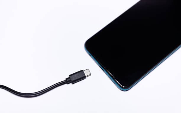 istock Smartphone and charging jack on a white background. Mobile device and charger cable. 1909988059