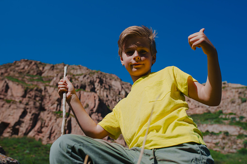 Boy hiker in the mountains gives a thumbs up
