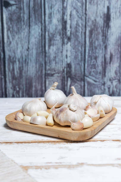 istock Ripe garlic in bamboo plate. Unpeeled raw garlic 1909989105