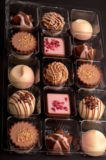 photography, set of assorted chocolates. The delicious promises a delightful indulgence, with each cocoa-infused treat offering a symphony of flavors and textures. A sweet confectionery delight. different, many, nourishment, close-up, elegance, unhealthy eating