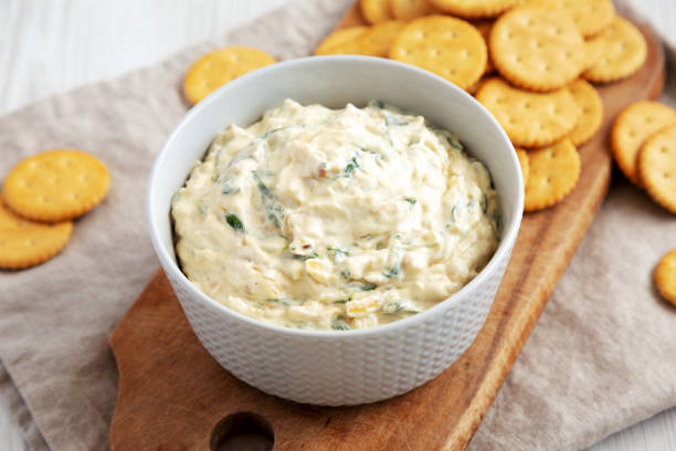 istock Homemade Caramelized Onion and Spinach Dip with Salty Round Crackers, side view. Close-up. 1910013819