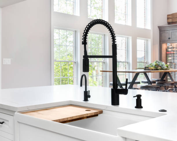 istock A black faucet on a white farmhouse sink. 1910026395