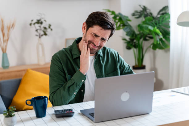 istock Pensive man holding cheek, suffering from dental pain. 1910034751