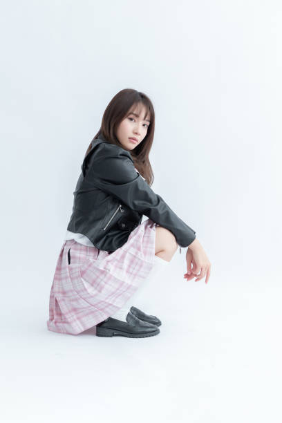 istock Asian school girl posing in a squatting position 1910036371